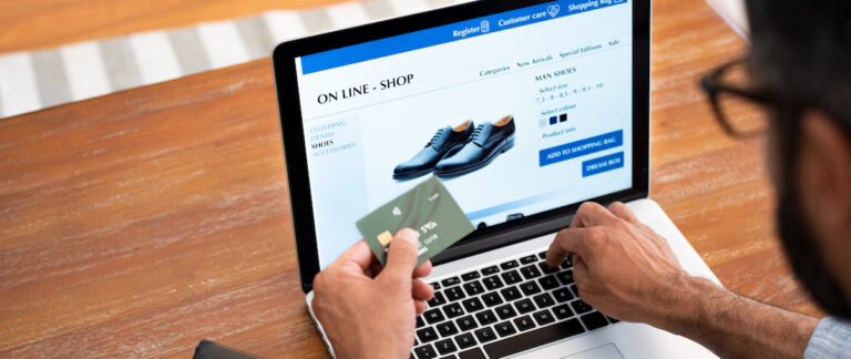 Man using credit card to do shopping online with laptop. Mature man buying formal shoes online. Man making online payment with credit card and laptop.