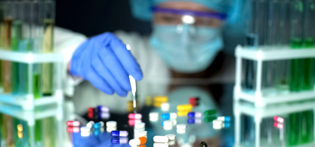 Lab assistant analyzing medication capsules, counterfeit pharmaceuticals, study