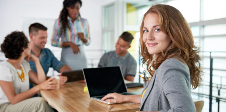Creative blond businesswoman leading hes team in a friendly conversation about their next agency project