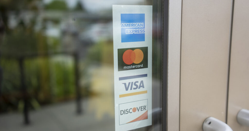 Image of a sign on the door indicating they accept all major card brands.