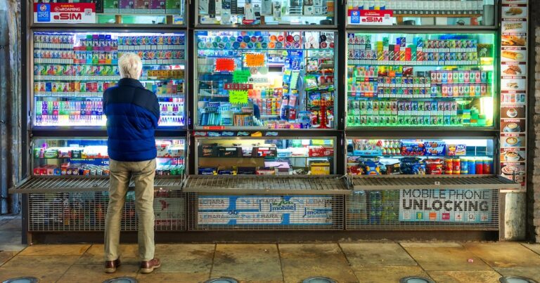 London, UK - 19 May, 2025: a senior man stands looking at a huge selection of disposable vapes at a kiosk in London, UK.