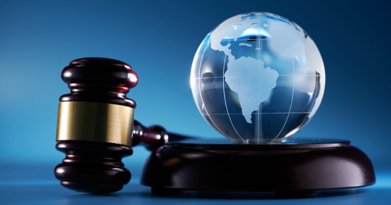 gavel hammer  and glass globe against blue background