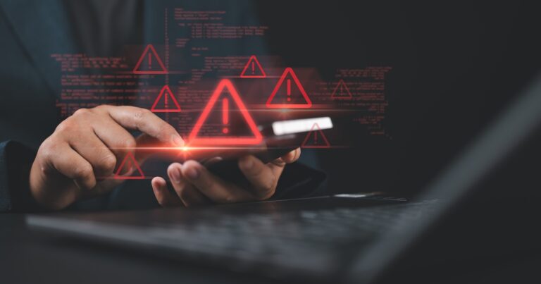 Man use smartphone and laptop with spam virus on warning caution for notification on internet security protect. Ransomware malware attack and data breach.