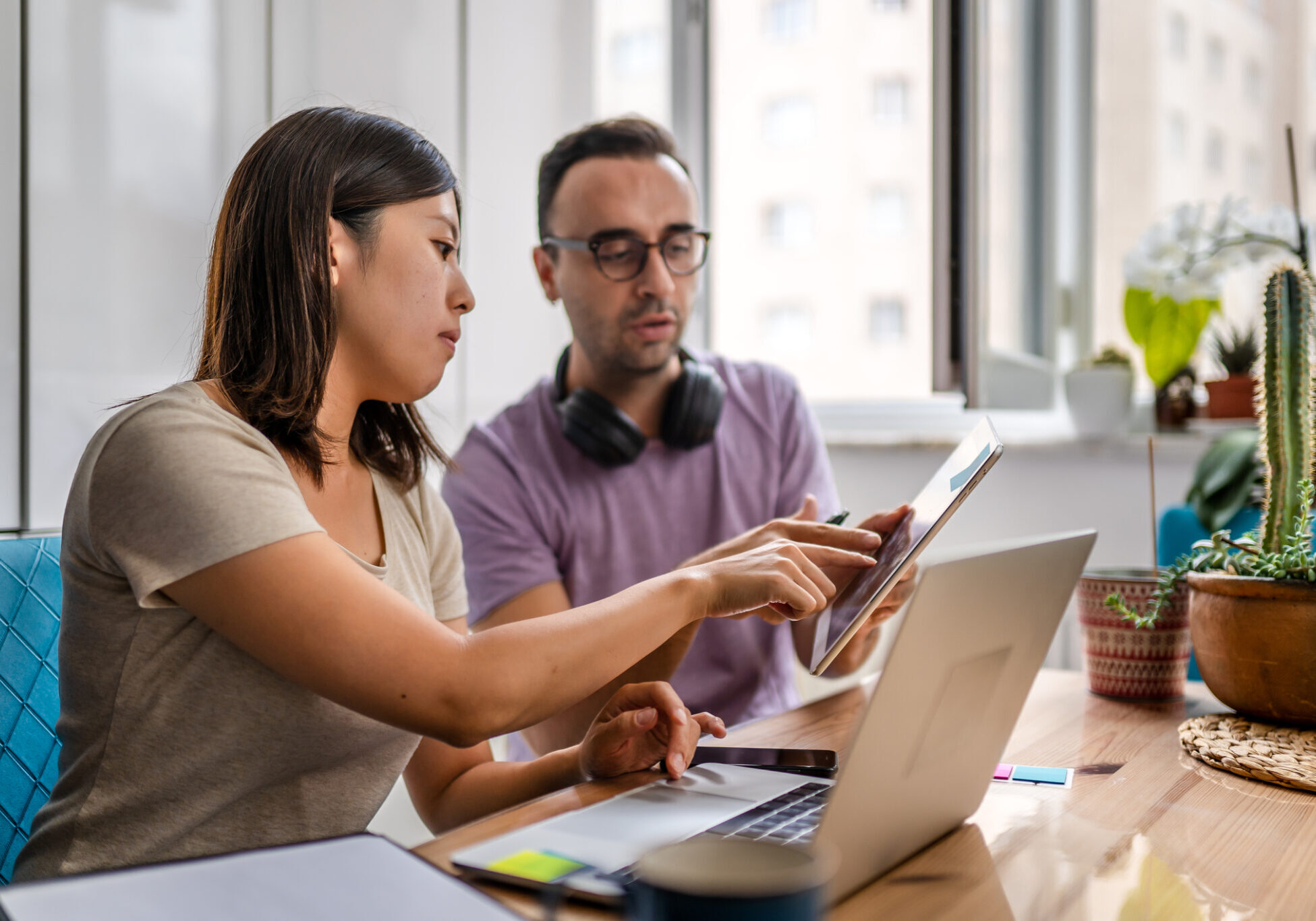 Young couple working at home and exchanging information about work