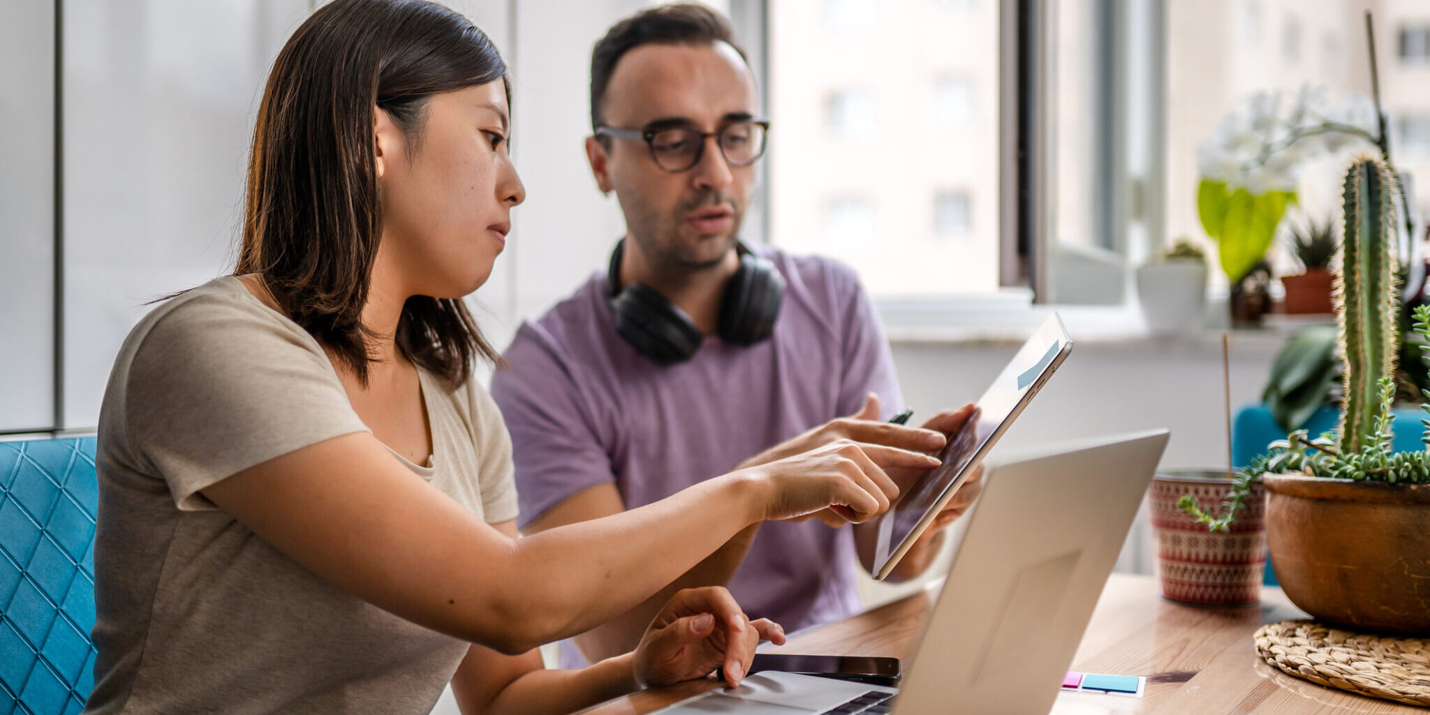 Young couple working at home and exchanging information about work
