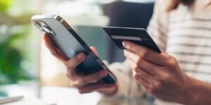 Woman hand holding credit cards and using smartphone for shopping online with payment on internet banking.