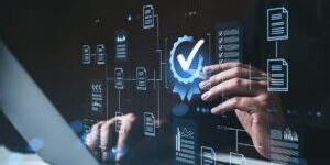 Businessman's hands using laptop with glowing digital interface showing checkmark badge and documents on dark background, concept of digital compliance SSUCv3H4sIAAAAAAAACpyS227DIAyG7yftHSKuG4lAeshepdqFA16DSiEC0mmq+u7jkFTsdnfxZ/u3f5zH+1vTkBG8EuSjeaQoxkrrxQcHQVkTMd2t3KGR6Gpyd/xAawCqjlCqYJ0CXcMRgpgM3DBCs2id8DMniQ8QFo8+7bIiAQEvUaPAl0RZ+FziZkvkZOyIKUJ2FfPLmNmGivi/OsvH58vwBY34yQtXRhxqhGLkXErJ9Tugu9XWYJHKVq7uVoBOBbxSAjWDgz99s1NCmUtFbJjyXTYlYRcTXNrqZYZoa2cYdXr1rzgGNz6B97FcbryaLeJfYG/VHGND9rSqEhmPk8KO95Sz05H1nLHjqWOntaAcdFJRJ6+zCcVYXJWsXam0AWF4GMRx2Ld72tG2Z13fDhK7lveIPVKgdODxFs9fAAAA//8DAKVcwVe5AgAA