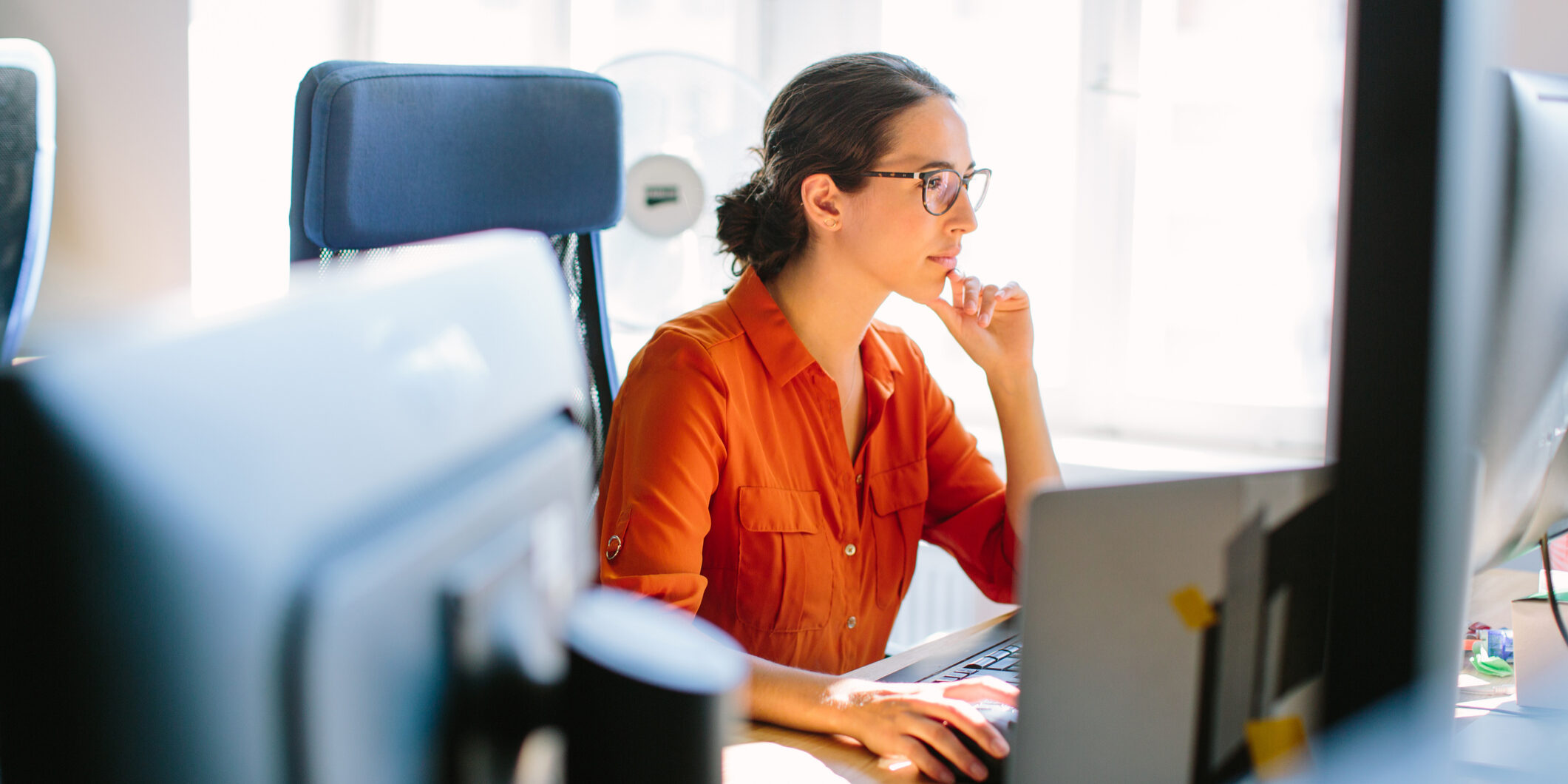 Shot of business woman sitting at her desk and working on desktop computer